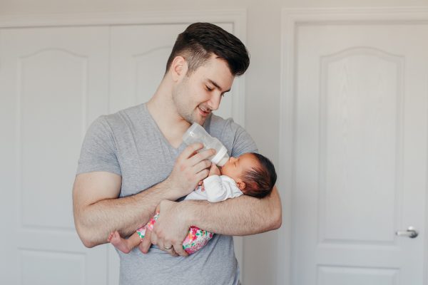 A Father feeding a Baby